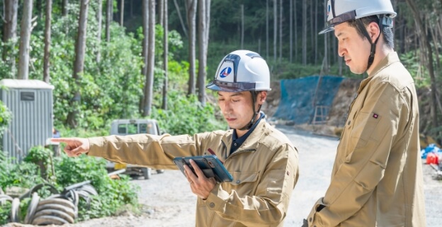タブレットを手に現場を確認する2名の作業員