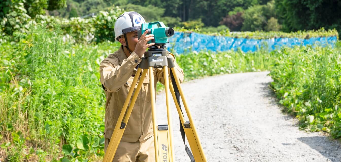 屋外で測量機器を操作する様子