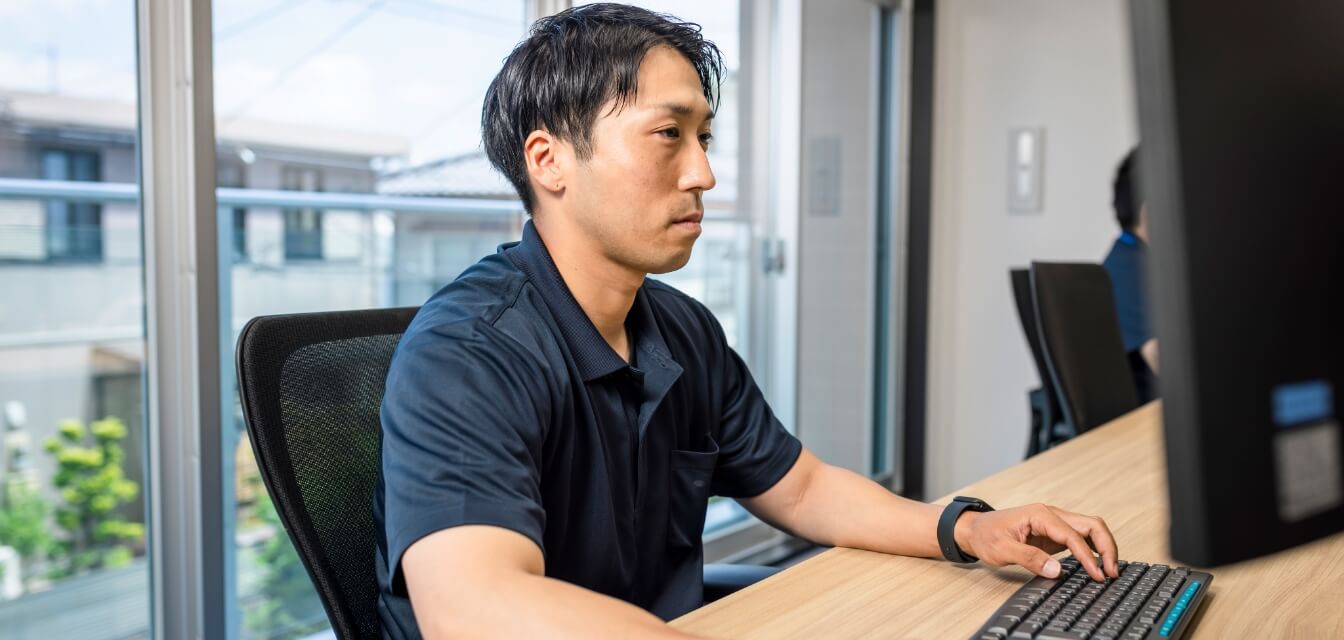 PCに向かって積算業務をする男性スタッフ