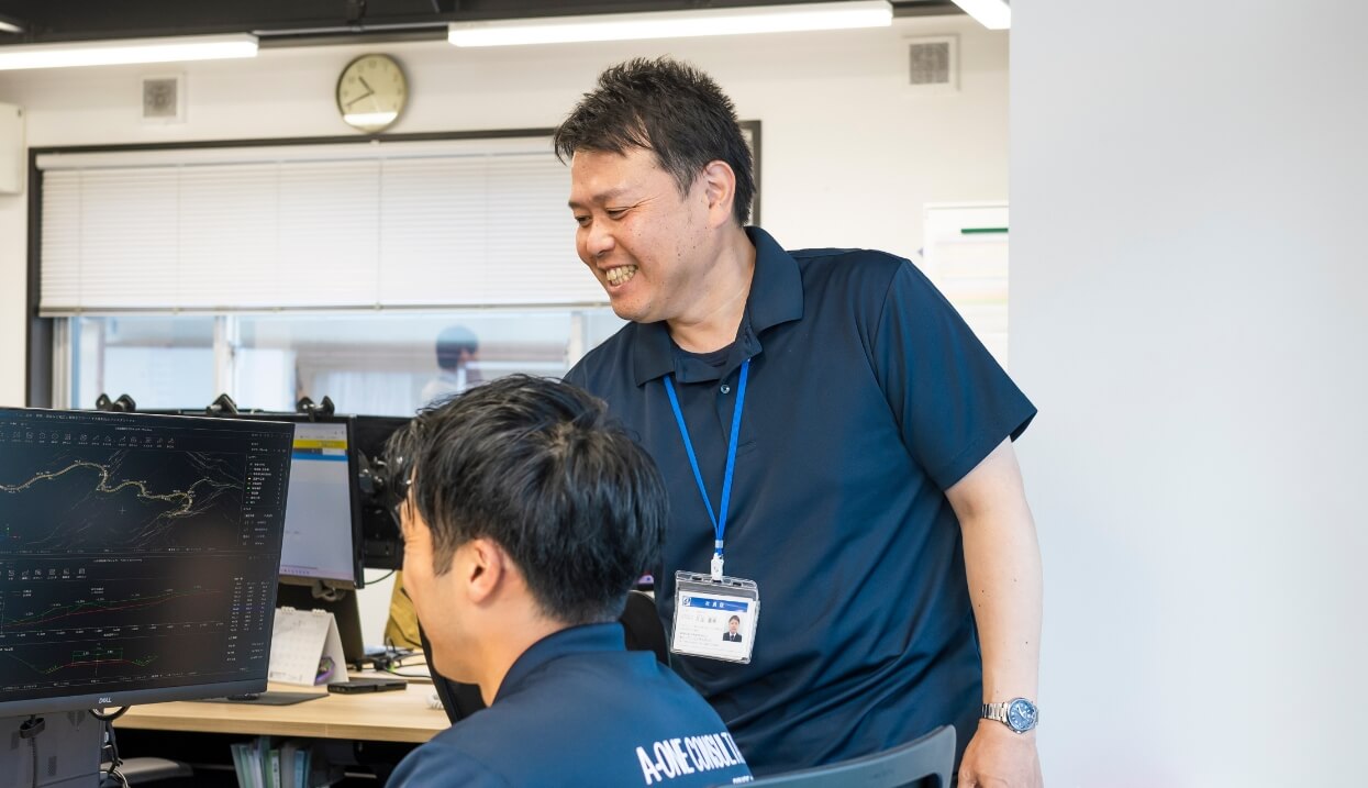 エーワンコンサルタントのスタッフ同士がオフィスで話している様子