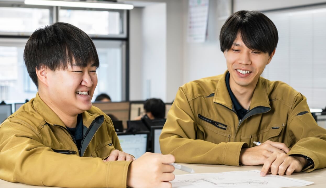 オフィスで話し合う男性スタッフ2名