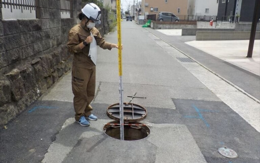 マンホールで作業する作業員