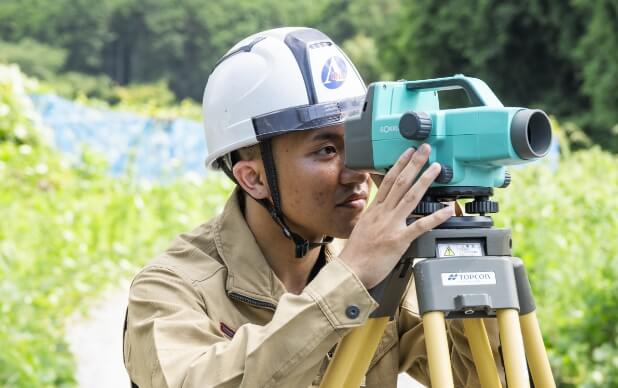 測量機器を覗き込む作業員